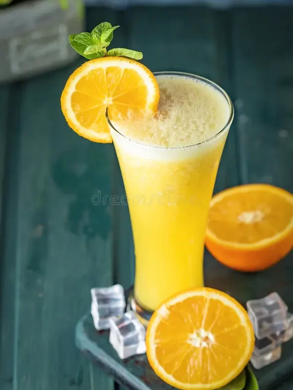 tall-glass-filled-frothy-orange-juice-garnished-fresh-slice-mint-leaves-ice-cubes-scattered-around-wooden-387791722