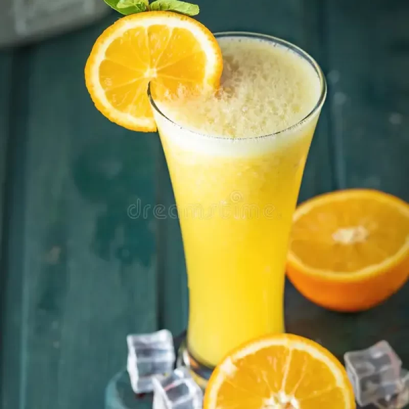 tall-glass-filled-frothy-orange-juice-garnished-fresh-slice-mint-leaves-ice-cubes-scattered-around-wooden-387791722